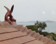 terracotta winged dragon overlooking sea in guernsey